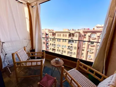 a balcony with chairs and a view of a building at Modern Gueliz Suite - Balcony Views in Marrakech