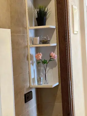 a bathroom shelf with a vase with flowers in it at Appart 2 chambres Gueliz in Marrakech