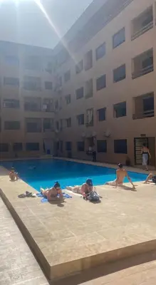 a group of people laying in a swimming pool at Appart 2 chambres Gueliz in Marrakech