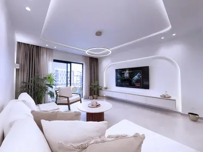 a living room with a white couch and a tv at Modern & luxurious apartment in Victor Hugo, Marrakech in Marrakech
