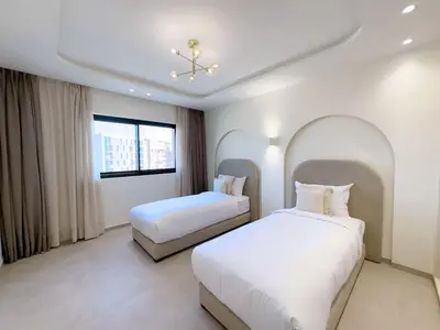 a hotel room with two beds and a window at Modern & luxurious apartment in Victor Hugo, Marrakech in Marrakech