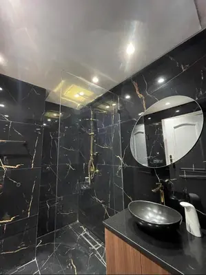a black bathroom with a sink and a mirror at Welcome to your peaceful getaway in Marrakech! in Marrakech