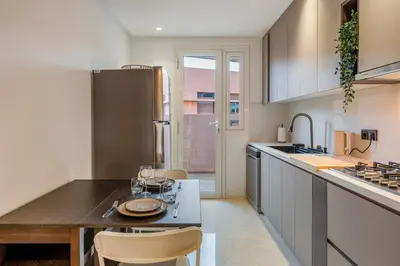 a kitchen with a table and some chairs in it at Le Nahla - Centre - 4 Prs - Terrasse in Marrakech