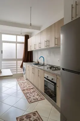 a kitchen with wooden cabinets and a stainless steel refrigerator at Spacious Apartment Near Menara Garden and Airport in Marrakech