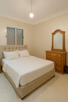a bedroom with a bed with a mirror and a dresser at Spacious Apartment Near Menara Garden and Airport in Marrakech