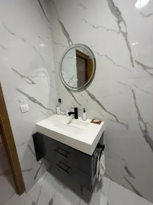 a bathroom with a sink and a mirror at Licht & ruim 2-slaapkamer appartement met airco & Wifi - rustig wijk Marrakesh in Marrakech