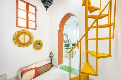 a living room with a yellow staircase and a mirror at Casa Coloré terrace and bohemian charm in Marrakech