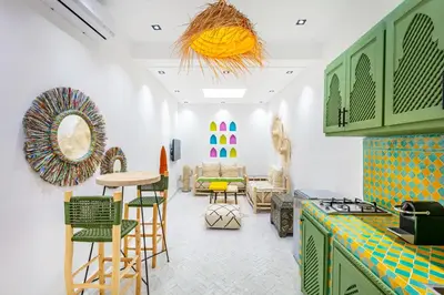 a room with a kitchen with chairs and a table at Casa Coloré terrace and bohemian charm in Marrakech
