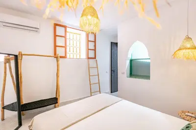 a bedroom with a bed and a ladder and a window at Casa Coloré terrace and bohemian charm in Marrakech