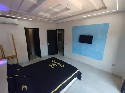 a room with a bed in a room with a tv at kech vacations 2 bedroom luxury gulize apartment in Marrakech
