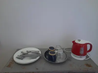 a table with a tea kettle and plates and utensils at Studio With Pool Marrakesh in Marrakech