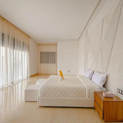 a white bedroom with a large bed and a table at Argan golf in Marrakech