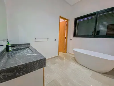 a bathroom with a large white tub and a window at Argan golf in Marrakech