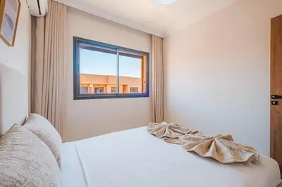 a bedroom with a white bed with a window at Modern 2 bedroom apartment Marrakech in Marrakech