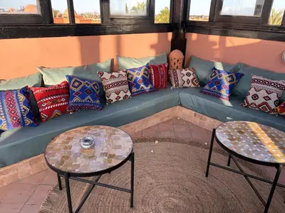 a blue couch with pillows on it with two tables at Atlas golf resort beldi chic piscine in Marrakech