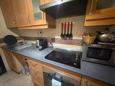 a kitchen with a stove and a microwave at Atlas golf resort beldi chic piscine in Marrakech