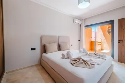 a bedroom with a large white bed with towels on it at Modern Studio with Pool in Marrakech