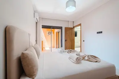 a white bedroom with a bed with towels on it at Modern Studio with Pool in Marrakech