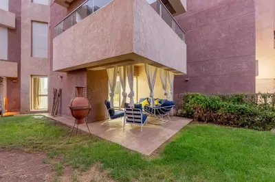 a house with a patio with chairs and a vase at Luxury apartment in Prestigia Opale in Marrakech