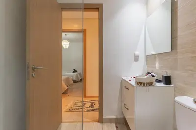 a bathroom with a glass door leading to a bedroom at Luxury apartment in Prestigia Opale in Marrakech