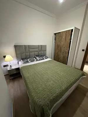 a bedroom with a large bed with a green blanket at 3wina immobilier in Marrakech