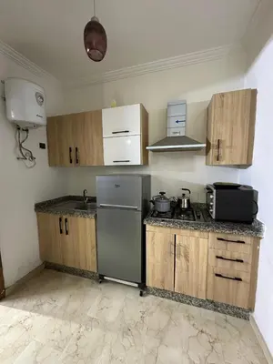 a kitchen with wooden cabinets and a stainless steel refrigerator at 3wina immobilier in Marrakech