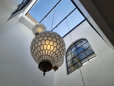 a large chandelier hanging from a ceiling with a window at Riad Dar Ninoun, Bassin chauffé & Petits déjeuners in Marrakech