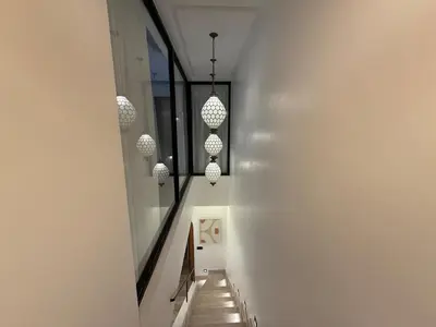 a hallway with white walls and chandeliers at Riad Dar Ninoun, Bassin chauffé & Petits déjeuners in Marrakech