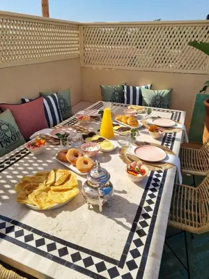 a table with plates of food on it at Riad Dar Ninoun, Bassin chauffé & Petits déjeuners in Marrakech