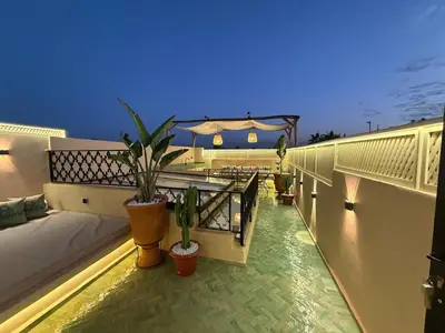 a balcony with potted plants on top of a building at Riad Dar Ninoun, Bassin chauffé & Petits déjeuners in Marrakech