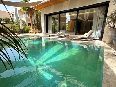 a swimming pool with blue water in a house at Palais Oyena in Marrakech