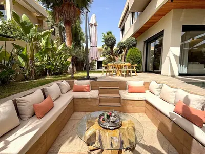 a patio with a couch and a glass table at Palais Oyena in Marrakech