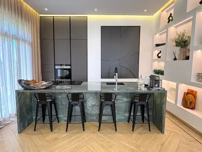 a kitchen with a large island with four bar stools at Palais Oyena in Marrakech