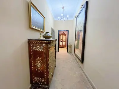 a hallway with a dresser and paintings on the wall at Villa avec piscine - Centre Gueliz in Marrakech