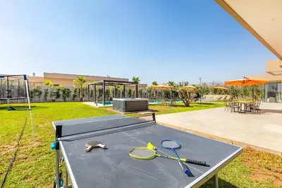 a ping pong table with two tennis rackets on it at Spacious villa with jacuzzi and activities in Marrakech