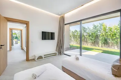 a bedroom with two beds and a large window at Spacious villa with jacuzzi and activities in Marrakech