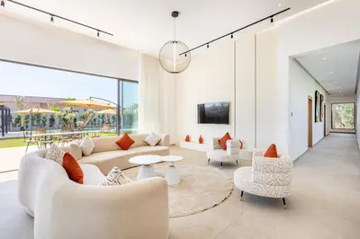 a living room with a couch and a table and chairs at Spacious villa with jacuzzi and activities in Marrakech