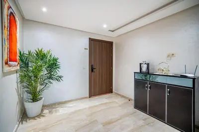 a room with a plant and a wooden door at Luxe City Escape 2BR Pool in Marrakech