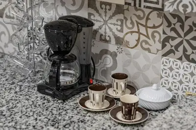 a blender sitting on a counter with four cups at Luxe City Escape 2BR Pool in Marrakech