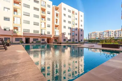a swimming pool in front of a building at Luxe City Escape 2BR Pool in Marrakech