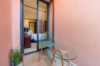 a glass table and a chair in a room at Luxe City Escape 2BR Pool in Marrakech