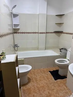 a bathroom with a toilet and a tub and a sink at 2 BR APP Gueliz Pool Ac Wifi in Marrakech
