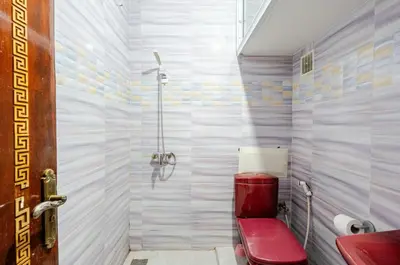a bathroom with a red toilet and a shower at Princess in Marrakech