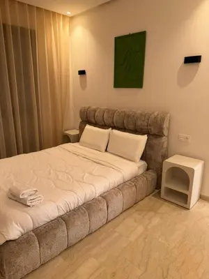 a bed with two pillows and a table in a room at Villa Wissam in Marrakech