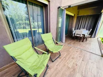 a patio with chairs and a table on a balcony at Luxury Prestigia Golf City jade in Marrakech