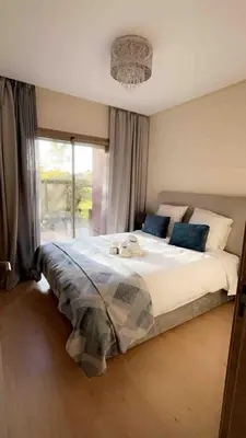 a bedroom with a large bed with a large window at Luxury Prestigia Golf City jade in Marrakech
