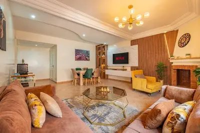 a living room with a couch and a table at Luxury 2BR Apt in Gueliz, Pools, Parking,Elevator in Marrakech