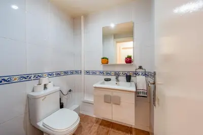 a white bathroom with a toilet and a sink at Luxury 2BR Apt in Gueliz, Pools, Parking,Elevator in Marrakech