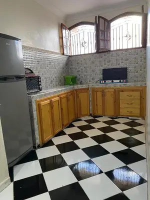 a kitchen with a black and white checkered floor at Garden View Comfort Apartment in Marrakech
