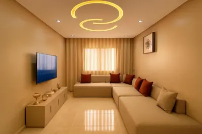 a living room with a couch and a tv at Appartement Confort & Sérénité Mabroka Marrakech in Marrakech